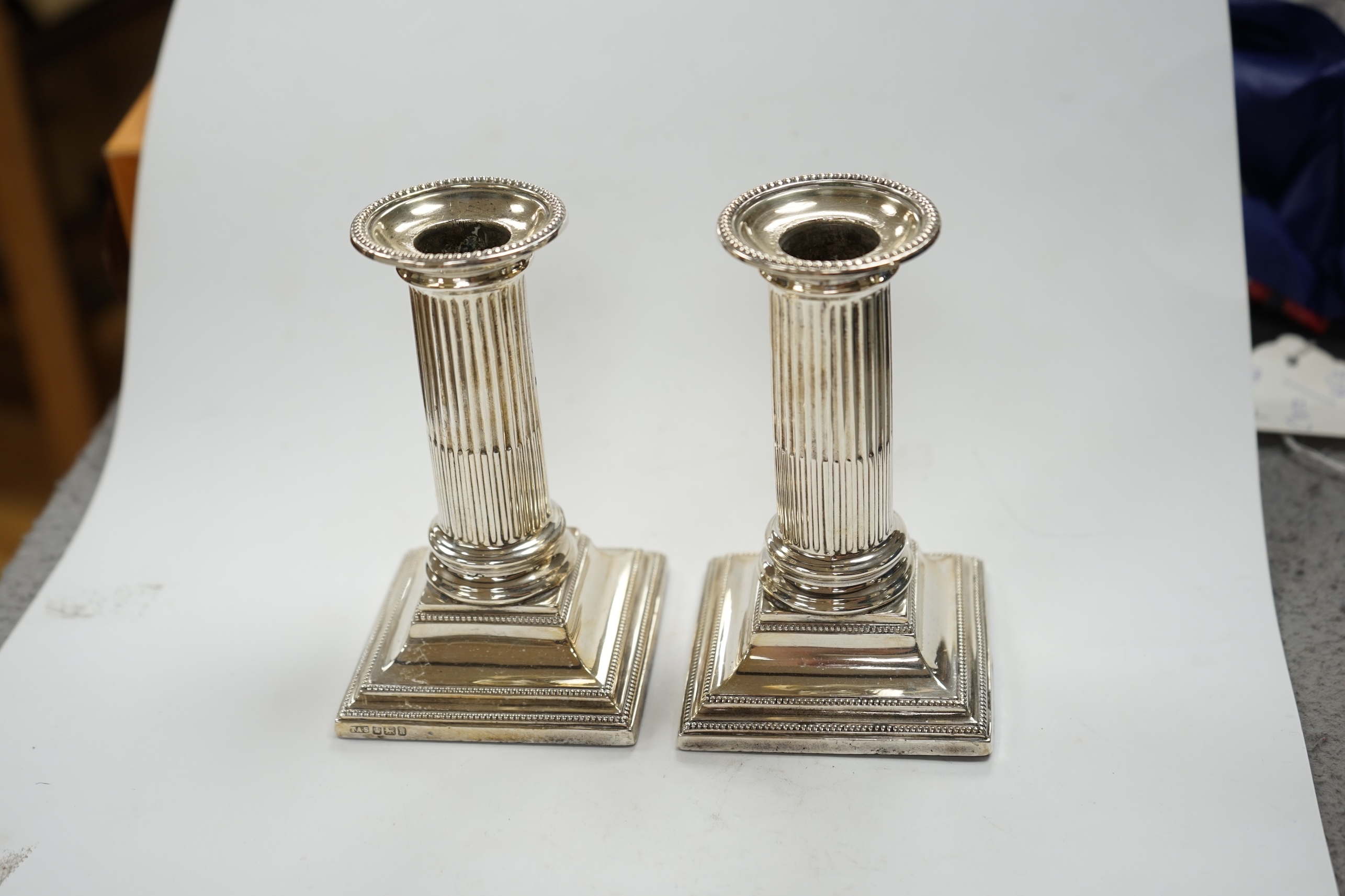 A pair of Edwardian silver dwarf candlesticks, Thomas A. Scott, Sheffield, 1905, height 12.5cm, weighted. Condition - fair